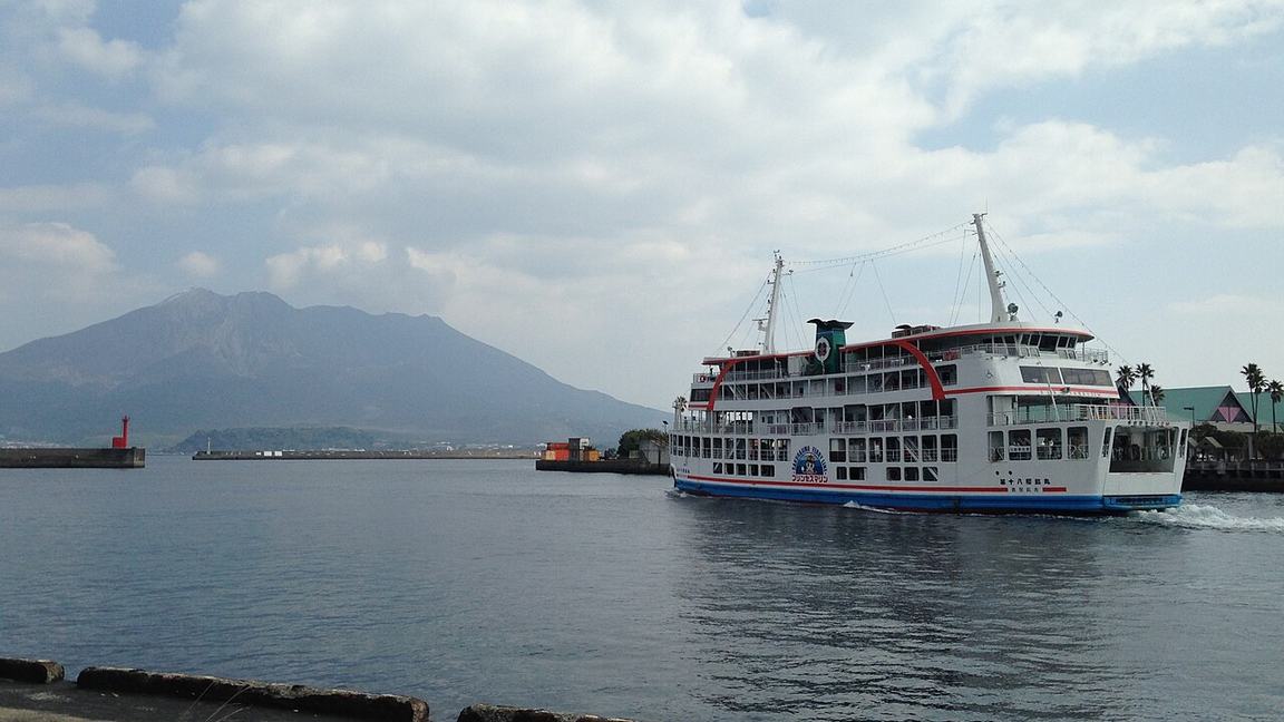 A ferry leaving Kagoshima port in Japan with the active volcano Sakurajima across the bay