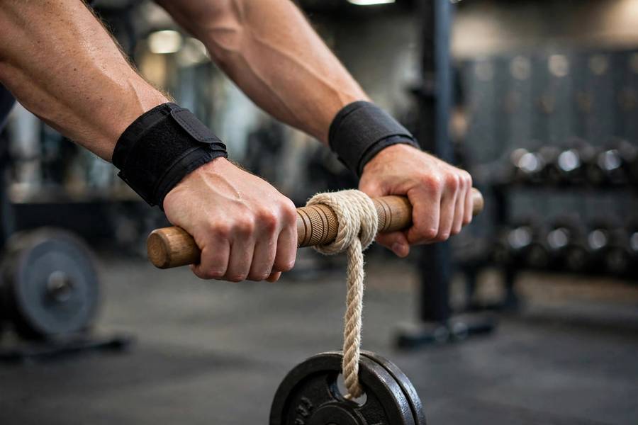 Close-up of muscular forearms during a wrist roller exercise