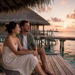 Couple in overwater bungalow in Maldives at sunset December