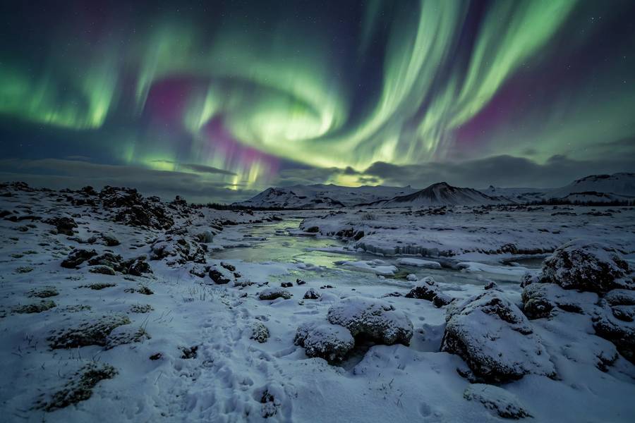 Northern Lights over Iceland with snow covered landscape
