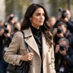Celebrity arriving at press photocall in stylish outfit, photographers in background, daytime event, photorealistic