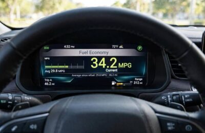 Car dashboard showing fuel economy MPG display affected by spark plug condition