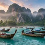 Longtail boats in calm turquoise water at sunrise — the best time to visit Thailand brings clear skies and flat seas