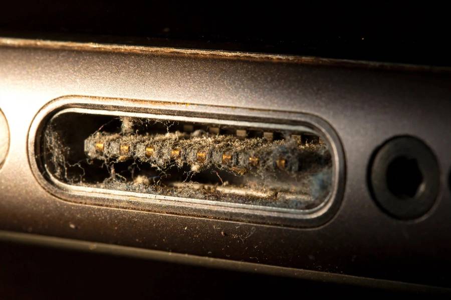 Close-up of an iPhone charging port needing cleaning