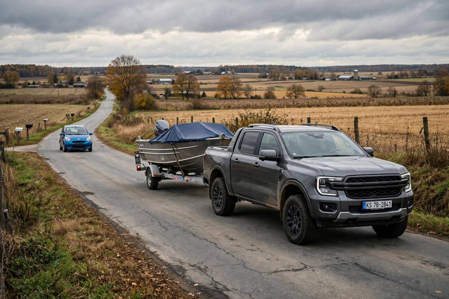 Pickup truck towing a boat on a rural road