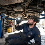 CVT Transmission Problems: 7 Signs Your Transmission Is Failing Mechanic inspecting a car's transmission on a lift in a repair shop