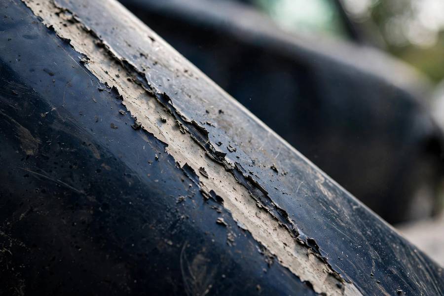 Close-up of a deep car scratch showing primer through the paint — do car scratches rust