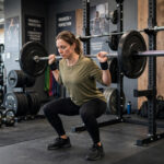 Endurance vs Strength Training: The Honest Guide to Doing Both Athlete doing barbell squats in gym strength session
