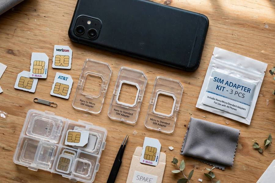 Physical SIM cards and adapters next to a smartphone for esim vs physical sim