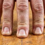 Close-up of fingers pressing into floor during a handstand hold
