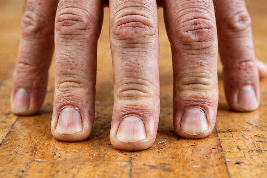 Close-up of fingers pressing into floor during a handstand hold
