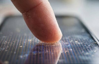 Fingertip touching a smartphone screen showing how a touchscreen works at the glass level