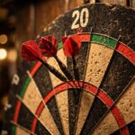 Dartboard showing darts scoring zones with darts in the treble 20