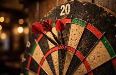 Dartboard showing darts scoring zones with darts in the treble 20