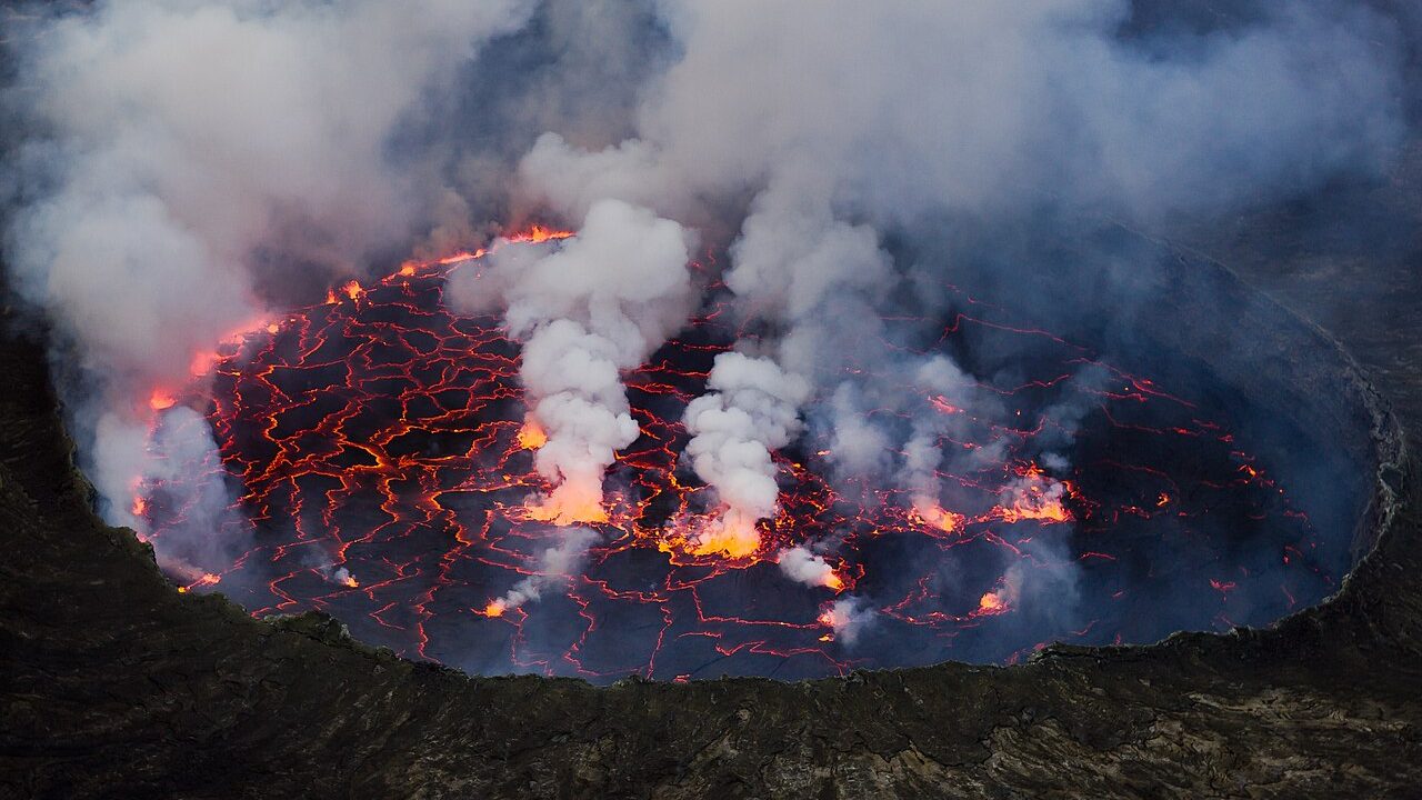 Aerial view of a lava lake with a cracked black crust and glowing orange lava showing through the cracks