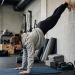 How Long Does It Take to Learn a Handstand? Honest Timelines Beginner practicing handstand against wall in first month of training