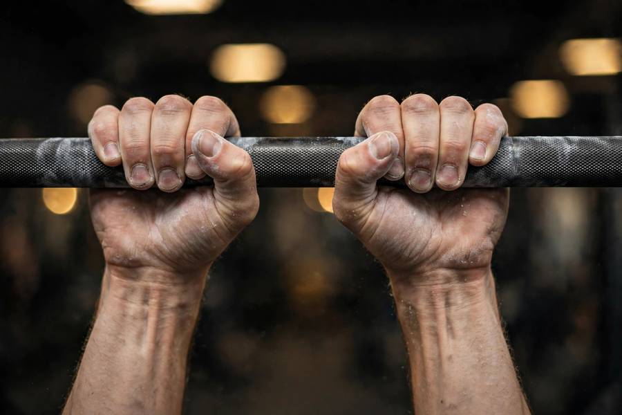 Close-up of hands gripping a pull-up bar before a max rep test