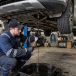 How Often Should You Change Your Oil? The Real Answer Mechanic draining old engine oil, illustrating how often should you change your oil