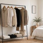 How to Build a Capsule Wardrobe: The Chic Guide to Doing More With Less Minimalist capsule wardrobe clothing rack with neutral-toned timeless garments in a bright bedroom