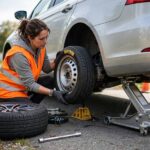 How to Change a Tire: A Mechanic's Step-by-Step Guide Driver changing a flat tire on the roadside, illustrating how to change a tire safely