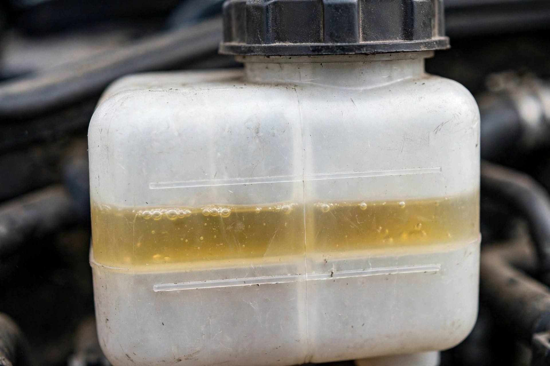 Car engine bay showing the brake fluid reservoir location