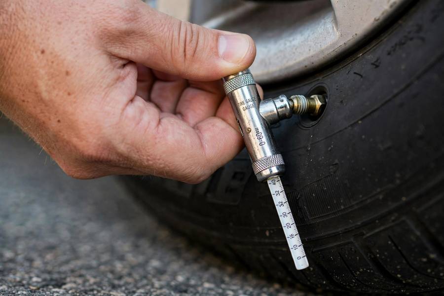 Reading tire pressure with a pencil gauge in how to check tire pressure step by step gauge