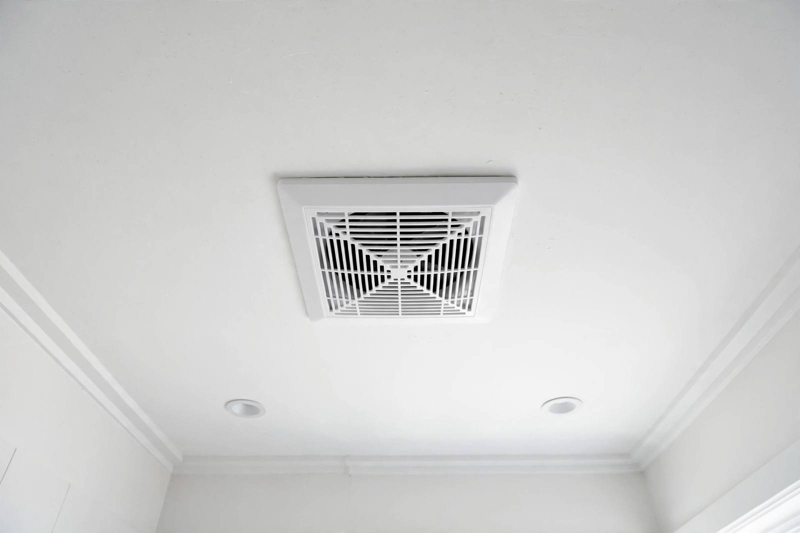 A clean bathroom ceiling with a freshly installed exhaust fan vent cover