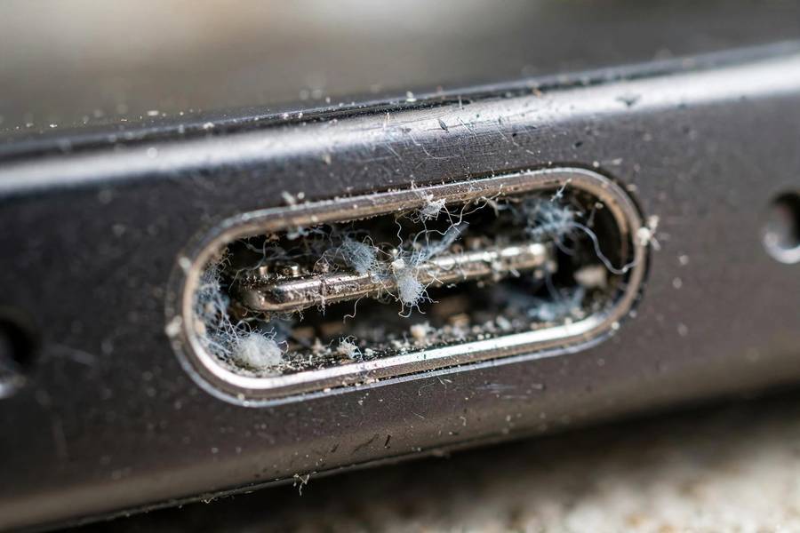 Lint packed inside an iPhone charging port that needs cleaning before it charges properly