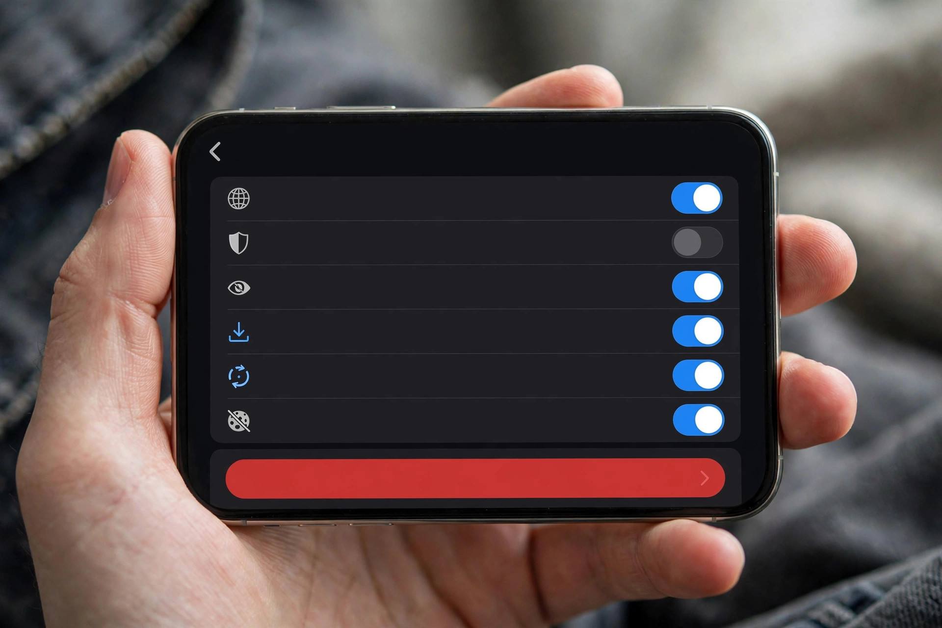 Hand holding an iPhone showing Safari settings screen with clear history option