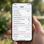 How to Clear Cache on iPhone: Every Method That Works Hand holding an iPhone showing the Settings app on screen