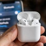 How to Connect AirPods: iPhone, Android, Mac & Windows (With Fixes That Work) AirPods in charging case next to iPhone showing how to connect AirPods