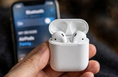 AirPods in charging case next to iPhone showing how to connect AirPods