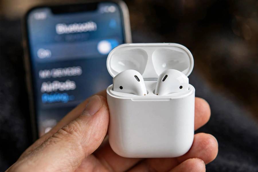 AirPods in charging case next to iPhone showing how to connect AirPods
