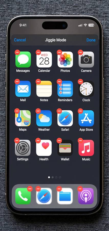 iPhone home screen in jiggle mode with app delete buttons visible