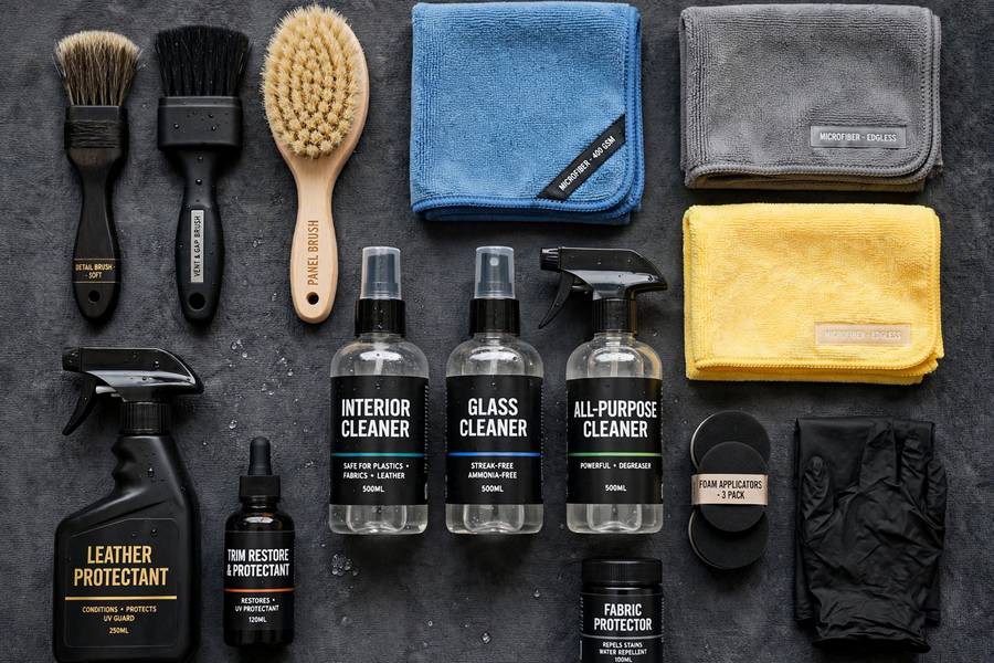 Professional products for how to detail car interior arranged on a table