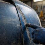 How to Fix a Car Scratch: Assess, Choose Your Method, Repair A mechanic assessing different types of scratches on a car fender