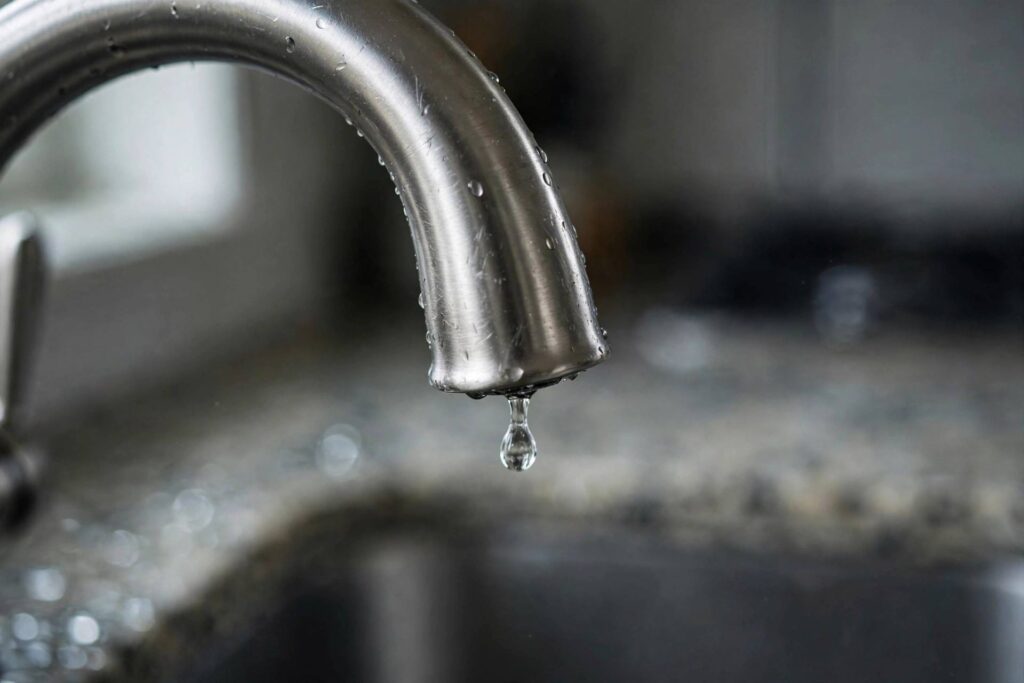 Kitchen faucet close-up with a single water drop