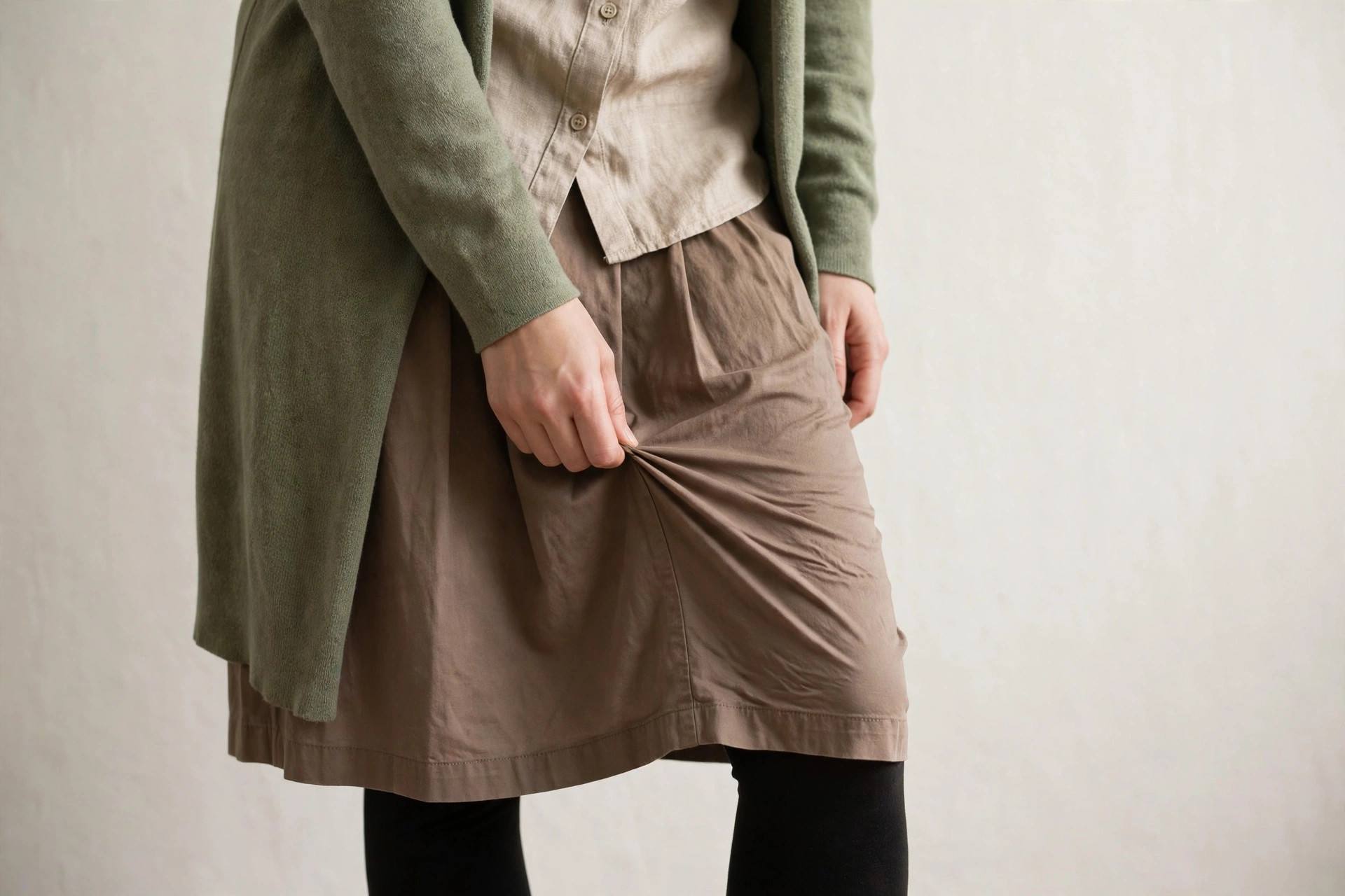Woman in modest full-coverage clothing dealing with static cling on a skirt