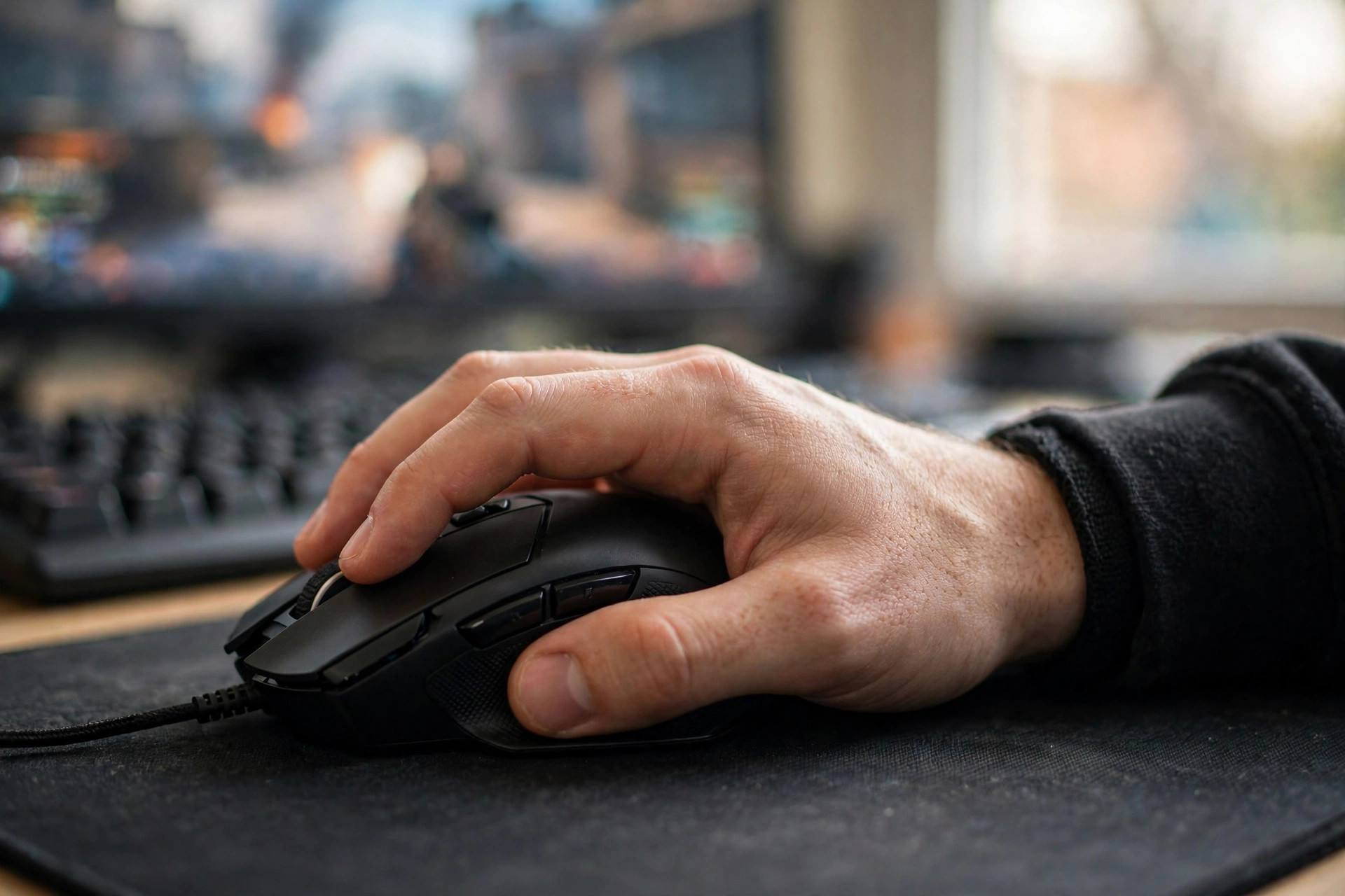Close-up of a gamer's hand on a mouse during an intense FPS match