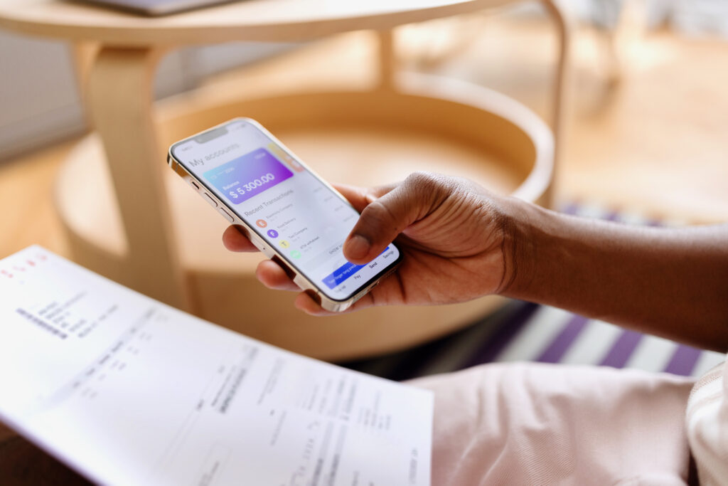 Person paying bills online through a mobile banking app on a smartphone