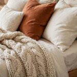 How to Make Your Bedroom Cozy: Small Changes That Make a Big Difference A cozy bedroom with warm lamplight and layered bedding