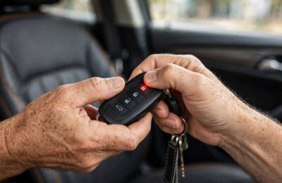 Hands pressing key fob buttons during the how to program a key fob procedure