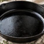 How to Season a Cast Iron Skillet (The Complete Guide) Well-seasoned cast iron skillet with glossy black cooking surface