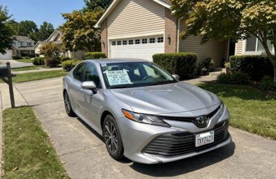 Car with for-sale sign in driveway, the first step in how to sell a car privately