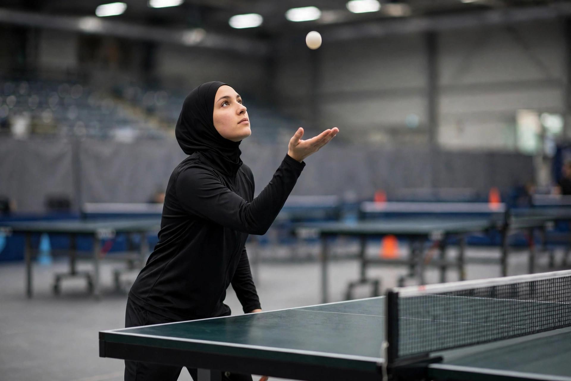 Table tennis player tossing the ball for a serve, showing the open flat palm technique