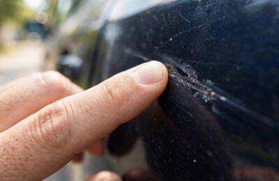 Hand doing the fingernail test to tell if a car scratch can be buffed out