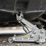 How to Use a Tire Jack Safely: A Mechanic's Safety Guide Scissor jack at the correct jack point showing how to use a tire jack safely