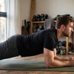 How to Do a Plank Correctly: Form Guide Man holding a forearm plank with straight body alignment, side view — how to do a plank correctly
