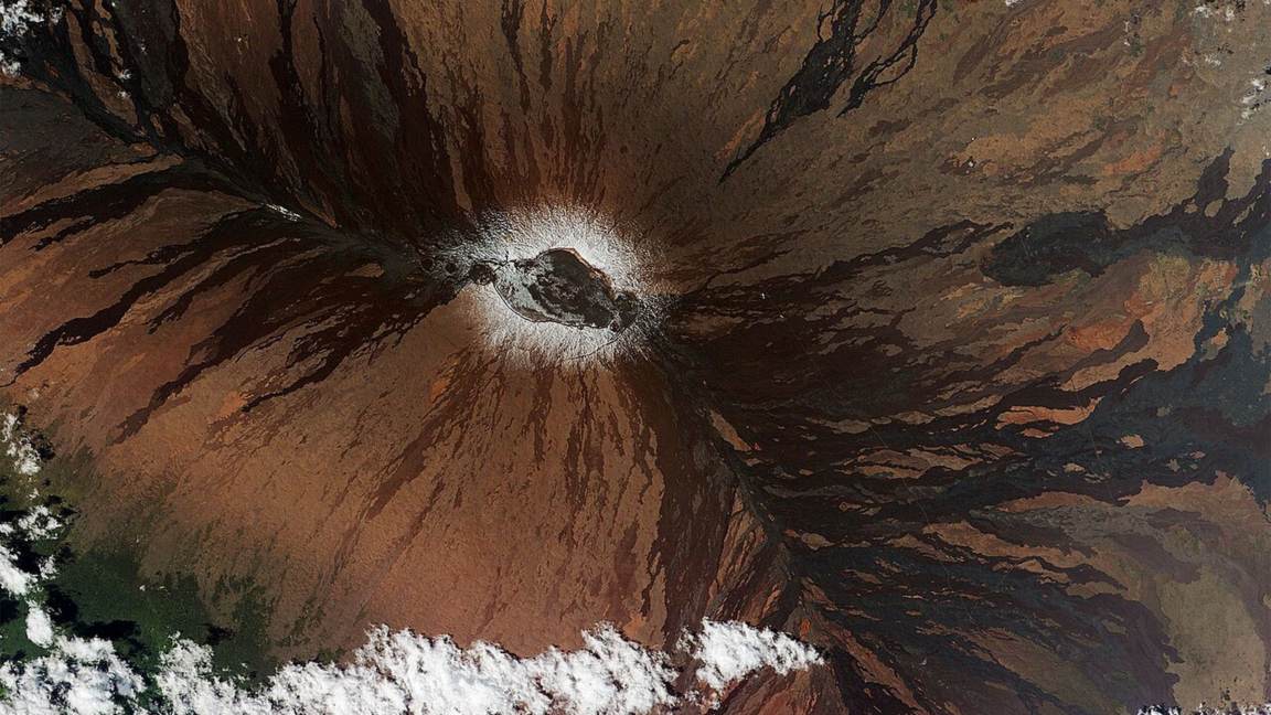 Satellite view of Mauna Loa's summit caldera with dark lava flows radiating across its wide shield