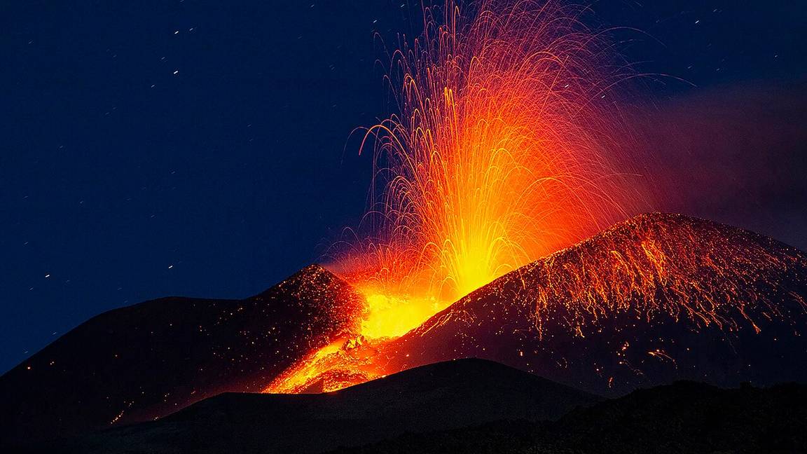 Mount Etna in Sicily erupting at night, throwing a fountain of lava into the sky